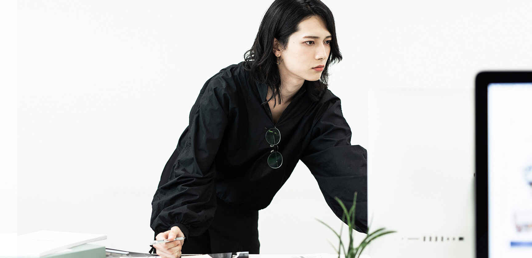 モニターを見つめる黒い服の男性