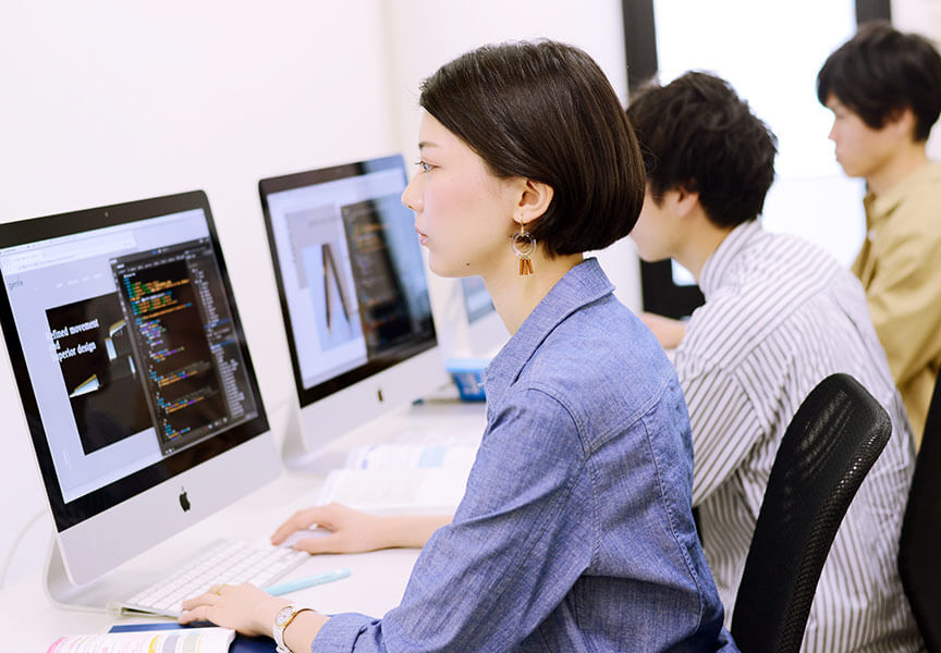 コンピューターでグラフィックデザインを学ぶ学生