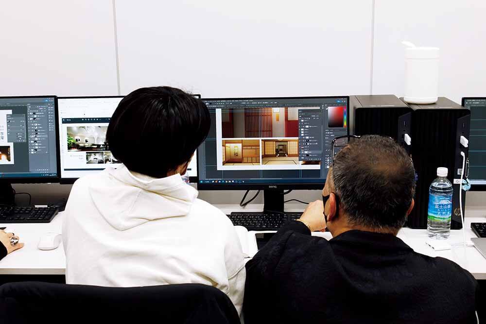 コンピューター画面を見ながら相談する二人